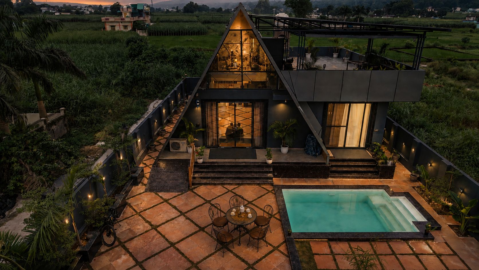 A modern villa with a swimming pool, outdoor seating, and a view of the surrounding landscape.