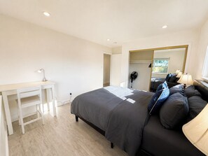 A bedroom with a bed, bedside table, lamp, and a mirror. - 8651-Peaceful 4-bedroom house with AC in charming Elk Grove (Elk Grove)