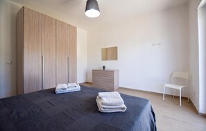Ein Schlafzimmer mit einem Bett, einem Schminktisch, einem Stuhl und einem Kleiderschrank.