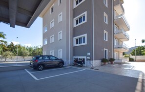 Ein mehrstöckiges Gebäude mit Parkplatz davor.