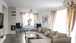 Un salon moderne avec un canapé d’angle, une table basse et un téléviseur.