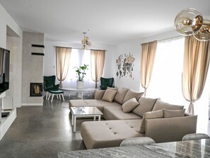 Una sala de estar moderna con un sofá modular, una mesa de centro y un televisor.