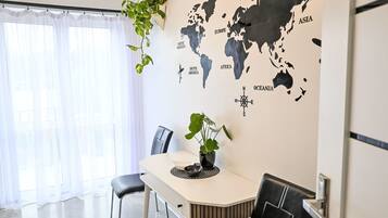 Comedor con un mural de un mapa mundial, una mesa, sillas y plantas en macetas.