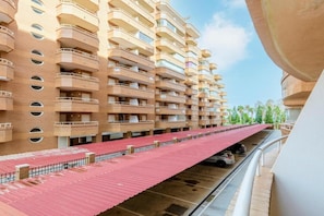 A multi-story hotel with balconies and a covered parking area. - Oropesa Apartment with Terrace (Orpesa)