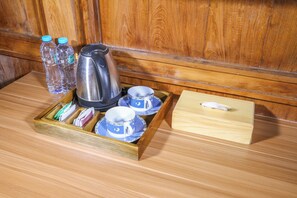 Ein Holztablett mit einem Wasserkocher, Tassen und einer Schachtel auf einem Holzboden.