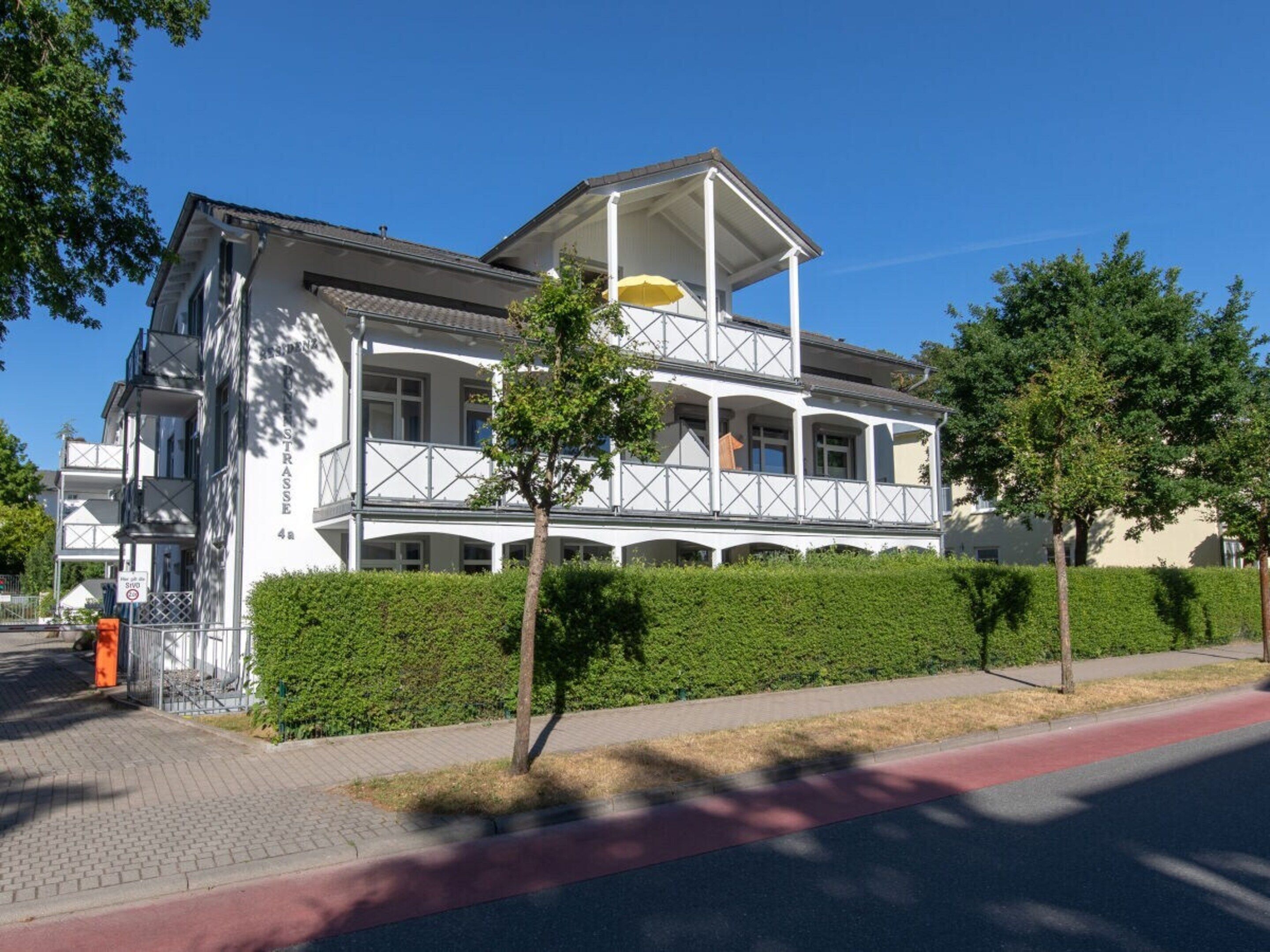 A two-story building with a balcony and a covered porch.