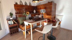 Ein gemütliches Zimmer mit einer Holzbank, einem Tisch mit Tablett, einem Bücherregal und einer Wandverzierung.