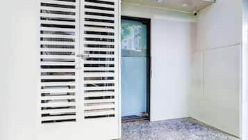 Un pasillo con una puerta blanca y una pared blanca con una rejilla de ventilación.