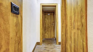 Un pasillo con paredes de madera y una puerta marcada con el número 202.