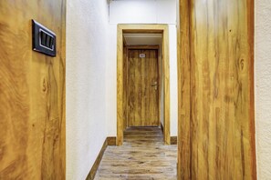 Un pasillo con paredes de madera y una puerta marcada con el número 202.