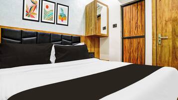 A bed with a black and white bedspread, a wooden headboard, and a wall-mounted mirror.
