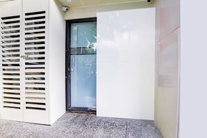 Puerta con un panel de vidrio, un pomo metálico y una cámara de seguridad encima.