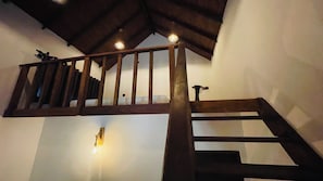 A wooden staircase with a handrail and a light fixture on the wall. - Divine Eco Resort Sigiriya (Sigiriya)