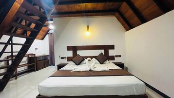 A bedroom with a wooden ceiling, a bed with a white mattress, two pillows, and a headboard.