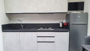 A modern kitchen with a built-in gas stove, a sink, a refrigerator, and a microwave.