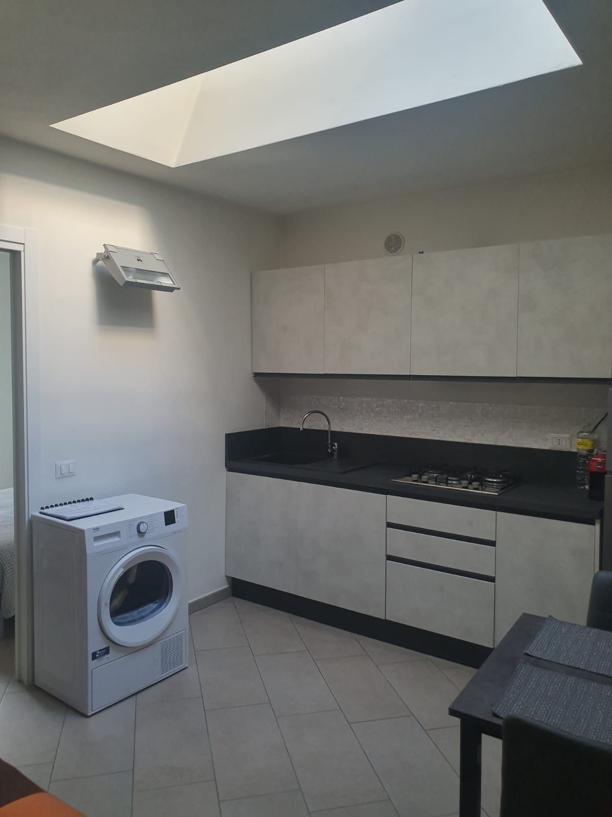 A compact kitchen with a built-in washer, a sink, and a gas stove.
