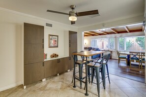 A modern kitchen with a wooden cabinet, a ceiling fan, and a dining area with a table and chairs. - Outdoor Oasis w/ Private Hot Tub! San Diego Gem (San Diego)