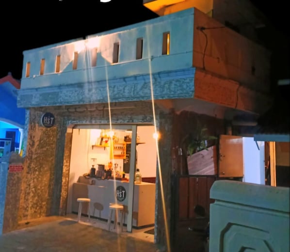 A building with a sign reading 'HST' and a bar area with stools. - HST Coffee and Homestay Wonosobo (Wonosobo)