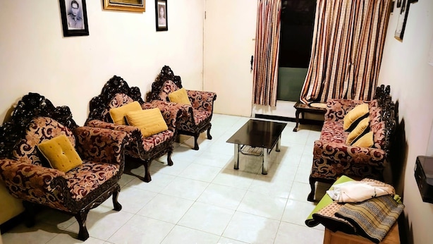 A living room with four patterned sofas, a coffee table, and a television. - HST Coffee and Homestay Wonosobo (Wonosobo)