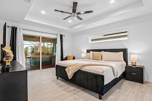 Une chambre à coucher moderne avec un grand lit, des lampes de chevet et un ventilateur de plafond.