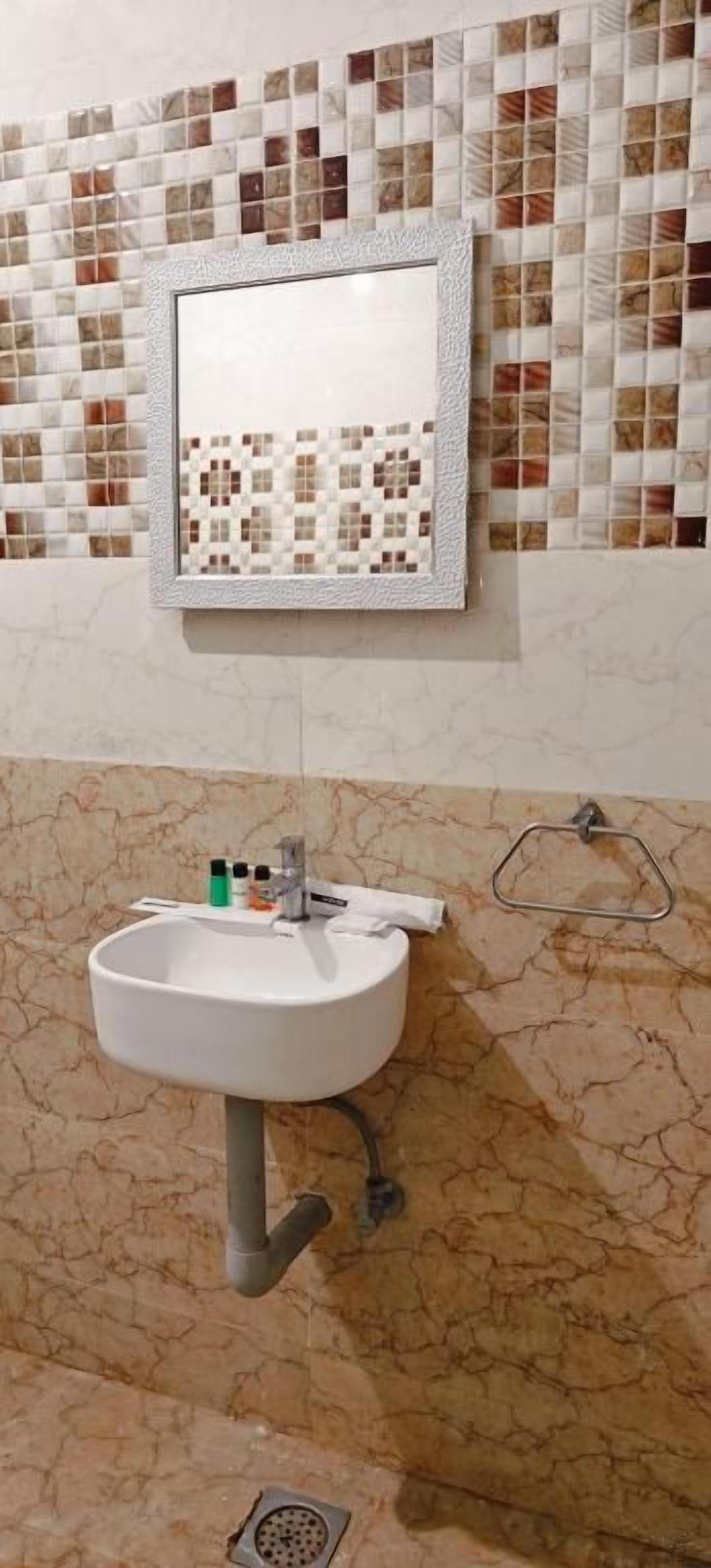 A bathroom with a sink, mirror, and tiled backsplash.