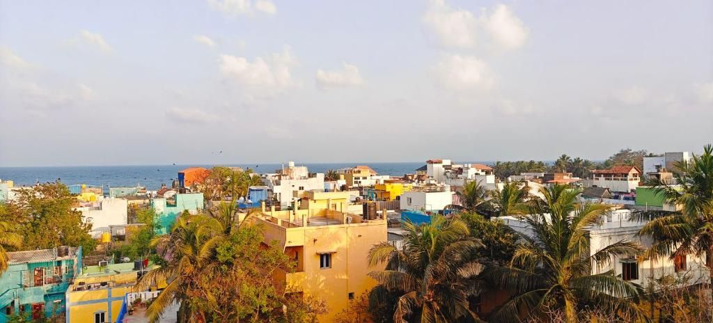 Un paisaje urbano costero con diversos edificios, incluyendo residenciales y comerciales, y una playa visible al fondo.