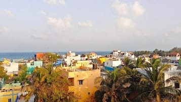 Un paisaje urbano costero con diversos edificios, incluyendo residenciales y comerciales, y una playa visible al fondo.