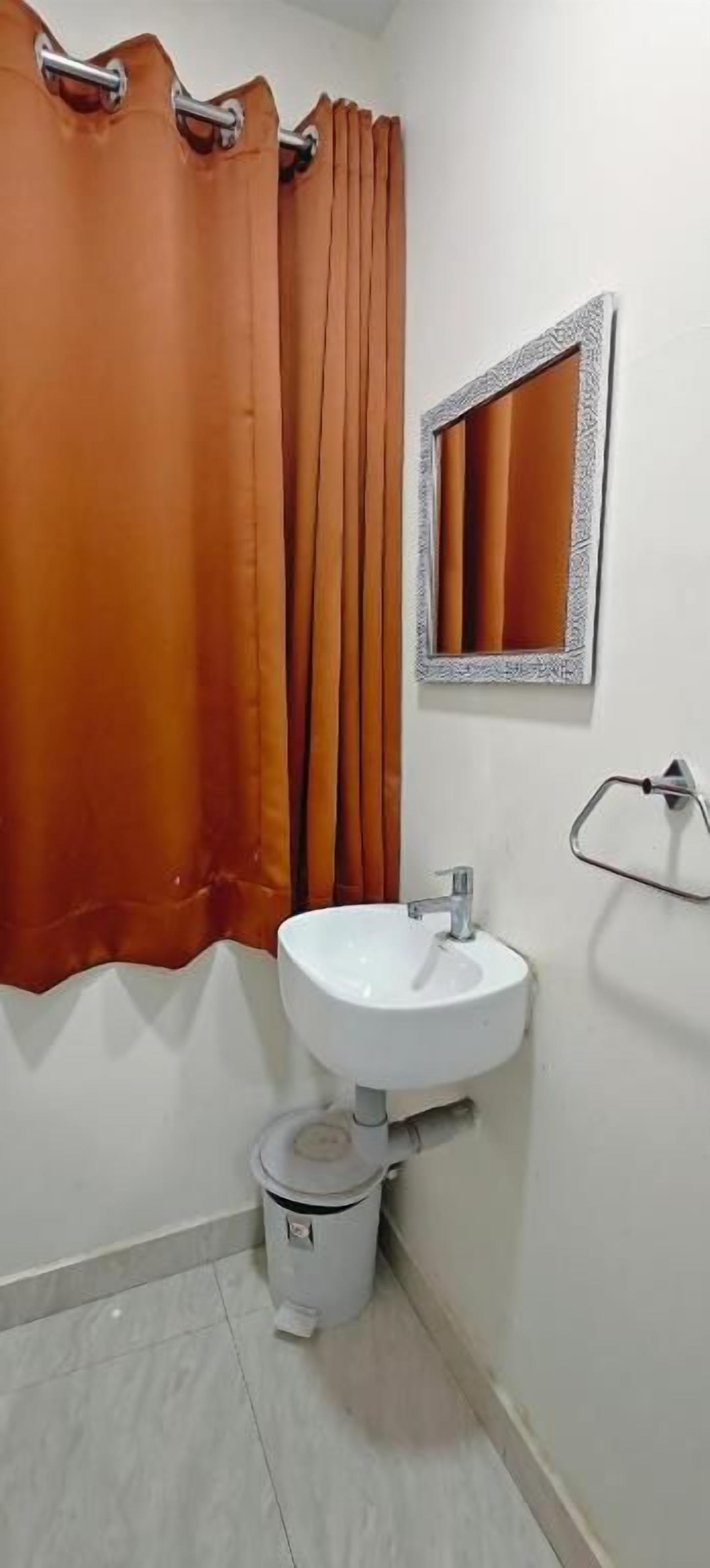 Un baño con lavamanos blanco, un espejo y un inodoro.
