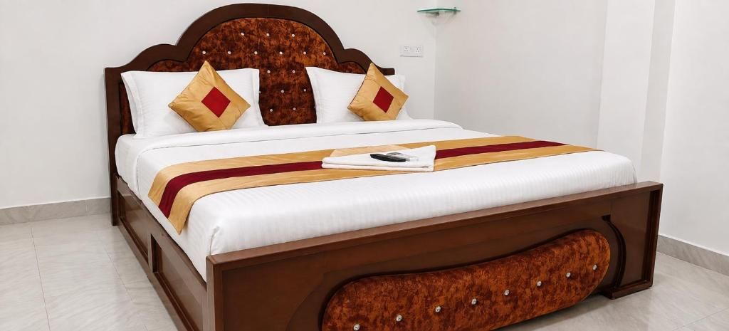 A bed with a wooden headboard, white bedding, and a red and yellow striped blanket.