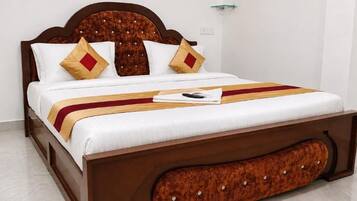 A bed with a wooden headboard, white bedding, and a red and yellow striped blanket.