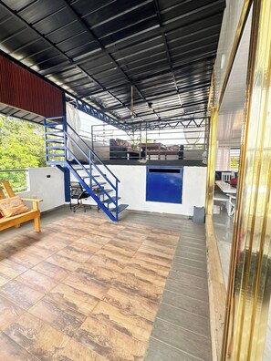 A covered outdoor area with a staircase, a seating area, and a kitchen counter. - - Bonao Yaneris Luxury Apartament (Bonao)