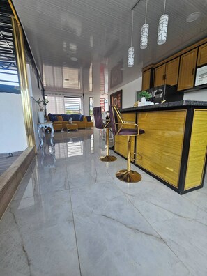 A modern kitchen with wooden cabinets, a black countertop, and a stainless steel refrigerator. - - Bonao Yaneris Luxury Apartament (Bonao)
