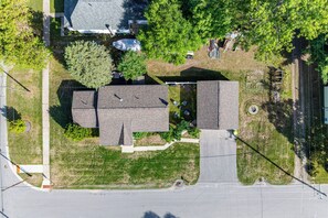An aerial view of a residential area with a large house, a smaller building, and a paved driveway. - Walk to Lake & Downtown! 6 Mi to Boyne Mtn (Boyne City)