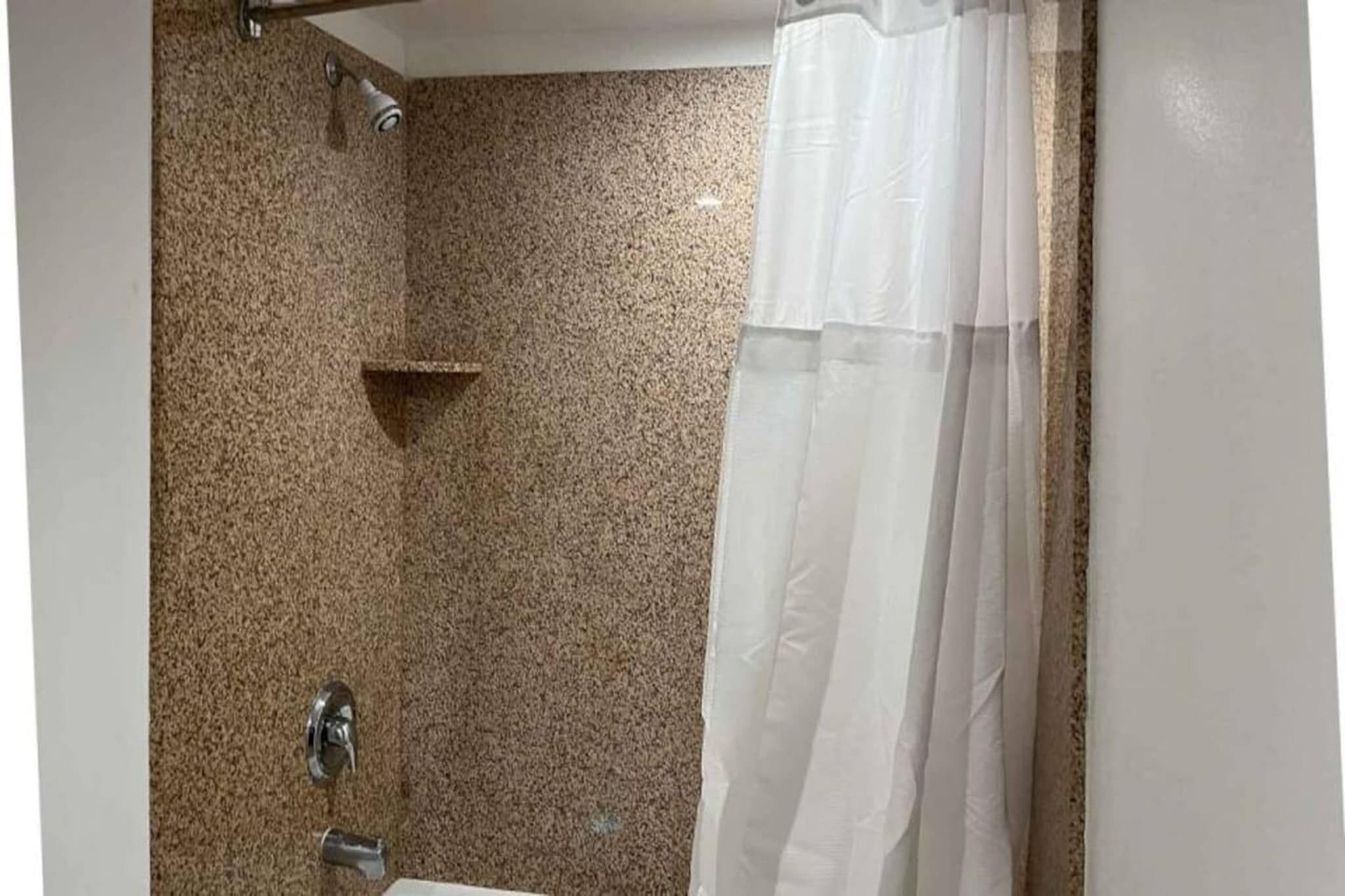 A bathroom with a shower, a towel rack, and a toilet.