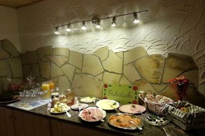 Un buffet della colazione con diversi cibi e un cartello con su scritto 'Frühstück'.