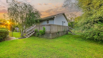 A house with a wooden deck and a staircase leading to the front door.
