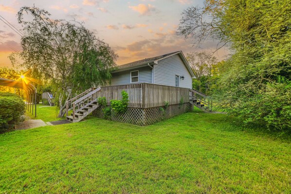 A house with a wooden deck and a staircase leading to the front door.