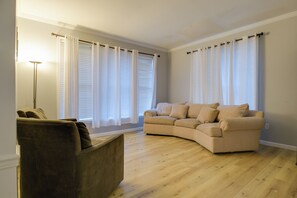 A living room with a beige sofa, a dark brown armchair, and a floor lamp. - 4 Mi to Dtwn Bel Air & Trails! Grand Home (Bel Air)