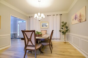 A dining room with a chandelier, a dining table, and chairs. There is a potted plant and a framed picture on the wall. - 4 Mi to Dtwn Bel Air & Trails! Grand Home (Bel Air)