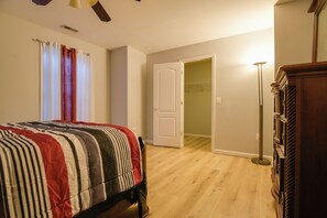 A bedroom with a bed, a wardrobe, a door leading to another room, and a floor lamp. - 4 Mi to Dtwn Bel Air & Trails! Grand Home (Bel Air)