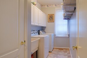 A laundry room with a washer and dryer, a window with blinds, and a door with a gold handle. - 4 Mi to Dtwn Bel Air & Trails! Grand Home (Bel Air)