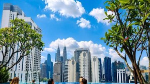 A swimming pool with a city skyline view, including tall buildings and a prominent tower. - Majestic Residence KLCC  by Maju Inn (Kuala Lumpur)