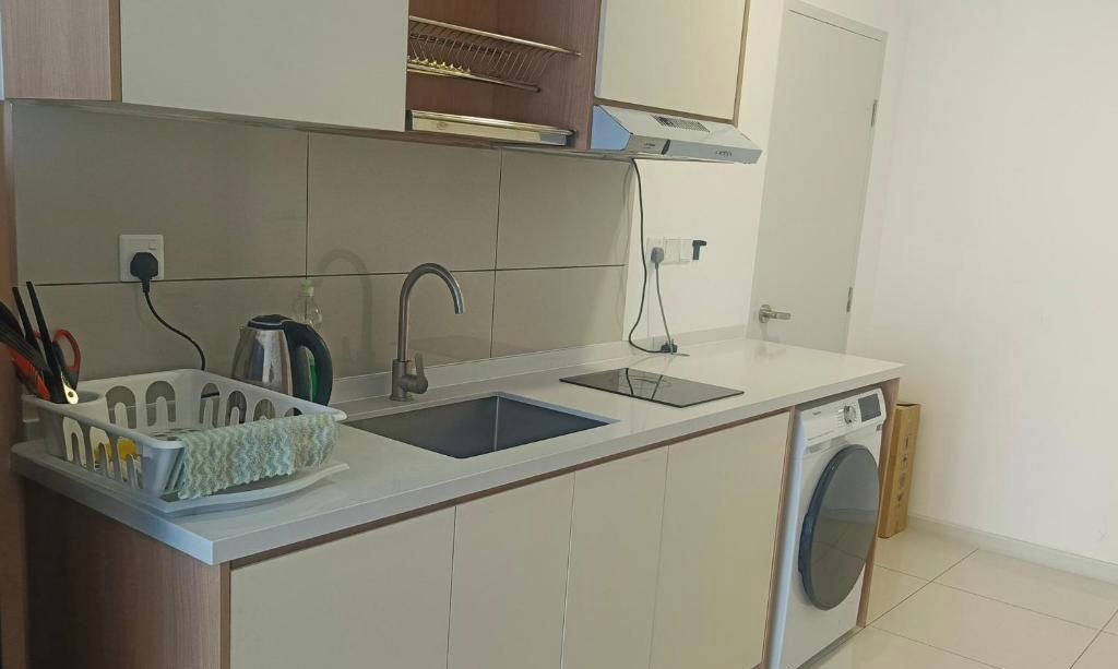 A compact kitchen with a double sink, a kettle, and a built-in washing machine.