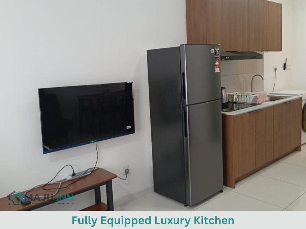 Cocina de lujo completamente equipada con refrigerador, un lavamanos y un televisor de pantalla plana montado en la pared.