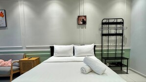A neatly made bed with white linens, a wooden headboard, and a black metal side table with a black metal shelf. - Majestic Residence KLCC  by Maju Inn (Kuala Lumpur)