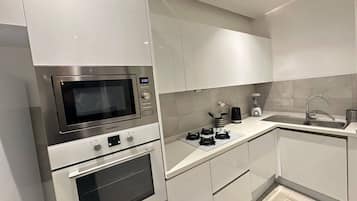 A modern kitchen with a built-in microwave, oven, and gas stove.