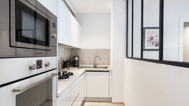 Una cucina moderna con elettrodomestici in acciaio inossidabile, forno integrato e lavello.