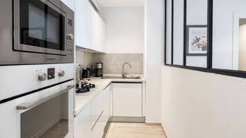 A modern kitchen with stainless steel appliances, a built-in oven, and a sink.