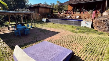 A patio area with a mattress, outdoor furniture, and a swimming pool.