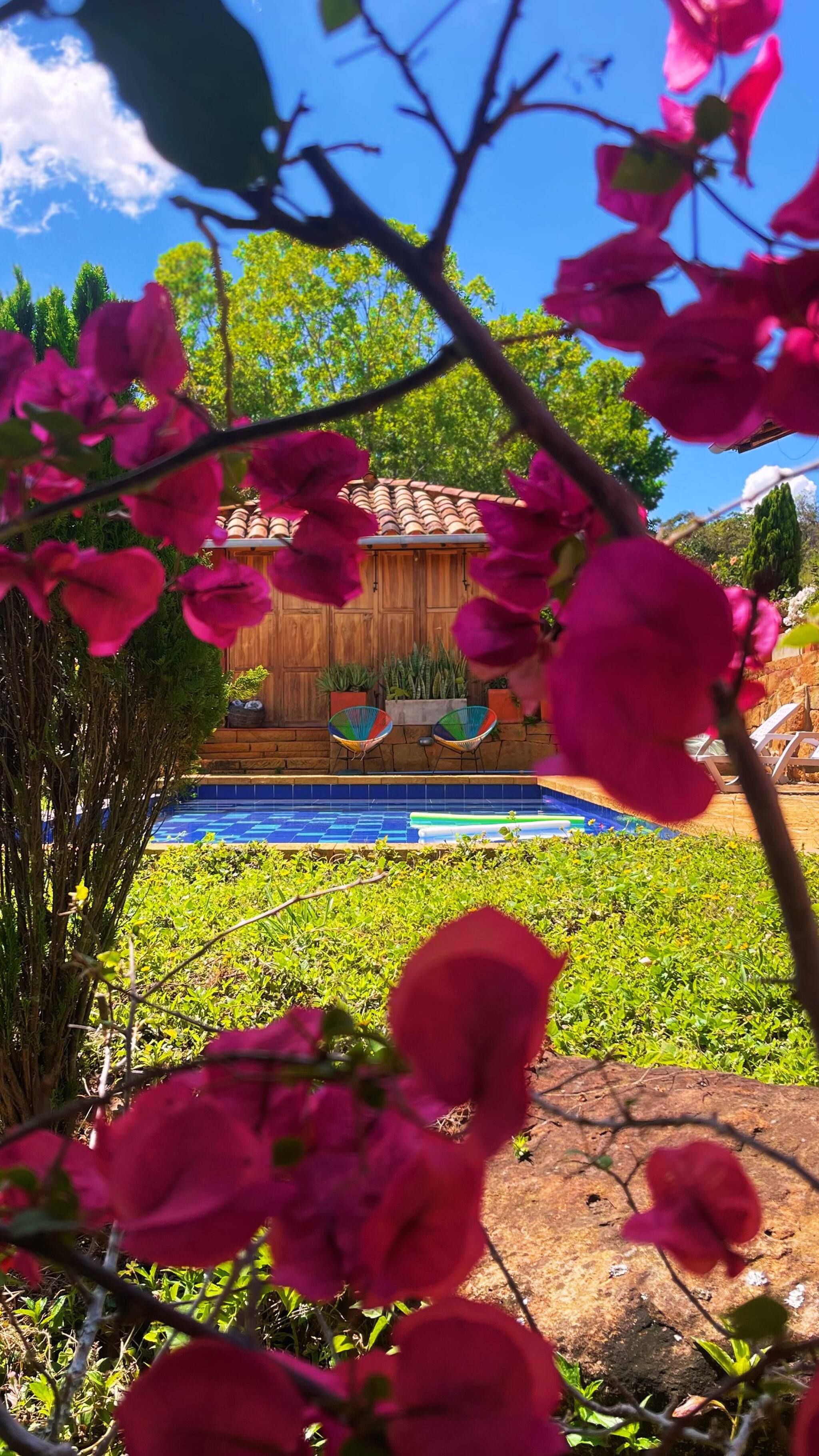 A pool area with a wooden deck and lounge chairs.